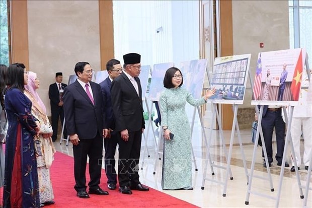 Le Premier ministre vietnamien, Pham Minh Chinh, et son homologue malaisien, Anwar Ibrahim, visitent une exposition sur les relations entre les deux pays. Photo : VNA.