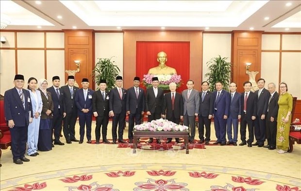 Le Secrétaire général Nguyên Phu Trong et le Premier ministre malaisien, Anwar Ibrahim, posent avec les délégués. Photo : VNA. 
