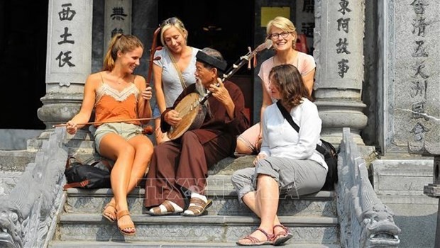 Des touristes étrangères découvrent des instruments de musique vietnamiens au temple Thai Vi, province de Ninh Binh. Photo : VNA.