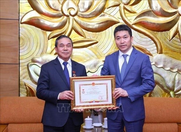 Le président de l'Union des organisations d'amitié du Vietnam Phan Anh Son (droite) remet l'Insigne "Pour la paix et l'amitié entre les nations" à l'ambassadeur du Laos au Vietnam Sengphet Houngboungnuang. Photo : VNA