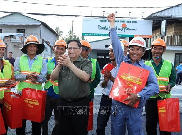 Le Premier ministre Pham Minh Chinh offre des cadeaux aux travailleurs sur le chantier de la construction d’une digue sur la rivière Cân Tho. Photo : VNA.