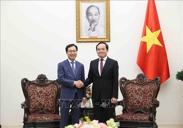 Le Vice-Premier ministre Trân Luu Quang (à droite) serre la main du directeur général de Samsung Vietnam Choi Joo Ho. Photo : VNA.