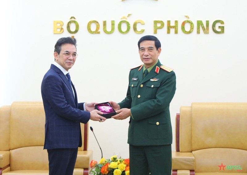 Le général Phan Van Giang (à droite) remet un cadeau de souvenir à l’ambassadeur thaïlandais Nikorndej Balankura. Photo: qdnd.vn