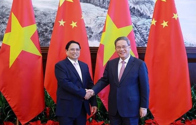 Le Premier ministre vietnamien Pham Minh Chinh (à gauche) et son homologue chinois Li Qiang se serrent la main, à Dalian, en Chine, le 24 juin. Photo : VNA.