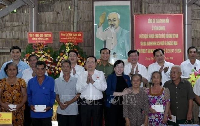 Le président de l'Assemblée nationale, Tran Thanh Man, offre des cadeaux à des familles bénéficiaires de politiques sociales et des personnes ayant rendu des services méritoires à la Révolution. Photo : VNA.