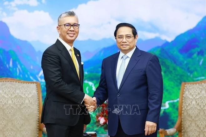 Le Premier ministre Pham Minh Chinh (droite) et le ministre malaisien de l'Investissement, du Commerce et de l'Industrie, Zafrul Abdul Aziz. Photo : VNA.