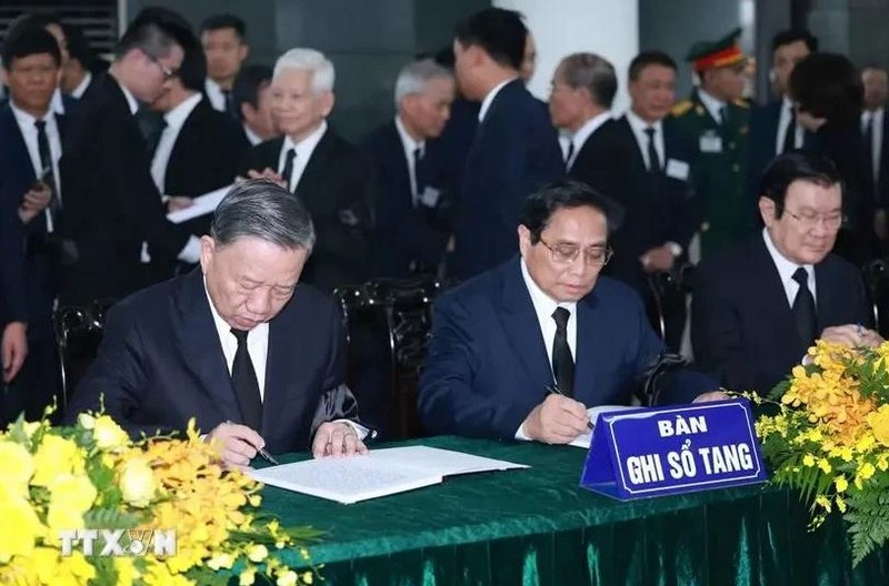 Le président To Lam (gauche) et le Premier ministre Pham Minh Chinh (centre) écrivent le registre de condoléances. Photo : VNA.