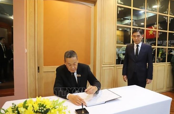 Le Premier ministre thaïlandais, Srettha Thavisin, écrit dans le registre de condoléances. Photo : VNA.