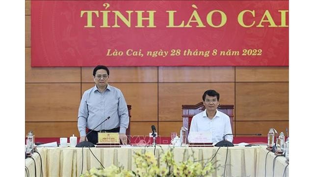 Le Premier ministre Pham Minh Chinh (debout) lors de la séance de travail avec des autorités de Lao Cai. Photo: VNA 