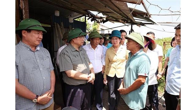 Le Premier ministre Pham Minh Chinh (2e à partir de la gauche) et des habitants de Ha Nam. Photo: VNA