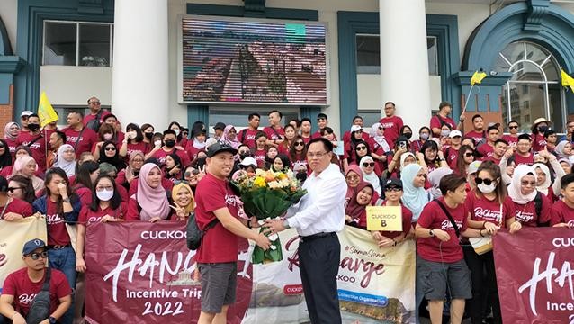 Le dirigeant du Service du Tourisme de Ha Long offre des fleurs à un groupe de tourisme venus de Malaisie. Photo : baoquangninh.vn