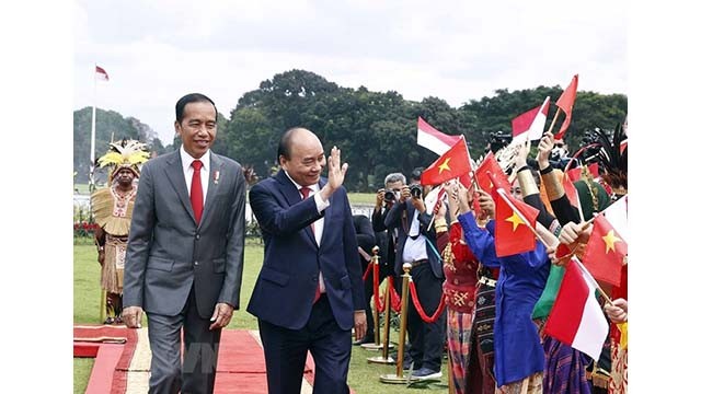 Le Président Nguyên Xuân Phuc (à gauche) et son homologue indonésien Joko Widodo à la cérémonie d’accueil officielle, le 22 octobre. Photo : VNA.