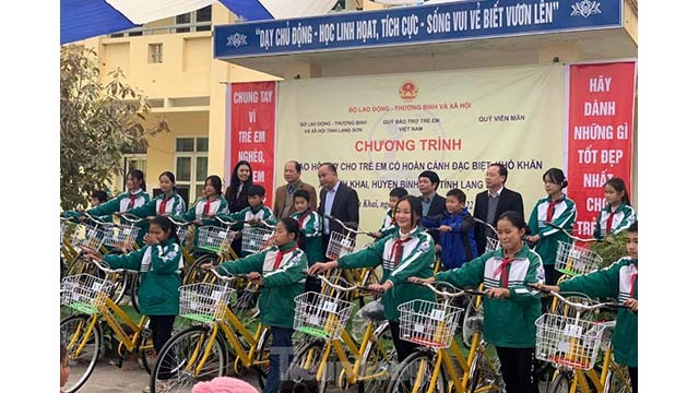 Le groupe de bénévoles a remis 110 bourses avec 1 million de dôngs chacune à 110 enfants démunis du district de Binh Gia ; 50 vélos et des équipements de jeux en plein air pour les enfants démunis du district de Gia Binh. Photo: Tienphong.vn