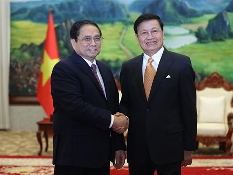 Le PM Pham Minh Chinh (à gauche) et le Secrétaire général du Parti révolutionnaire populaire lao et Président du Laos, Thongloun Sisoulithrencontre. Photo : VNA.