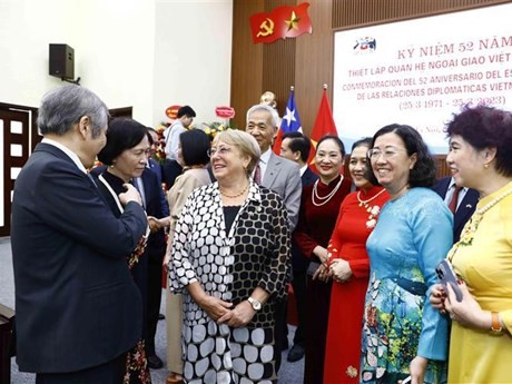 L’ancienne Présidente chilienne Michelle Bachelet avec les délégués lors de la cérémonie, à Hanoi, le 25 mars. Photo : VNA.