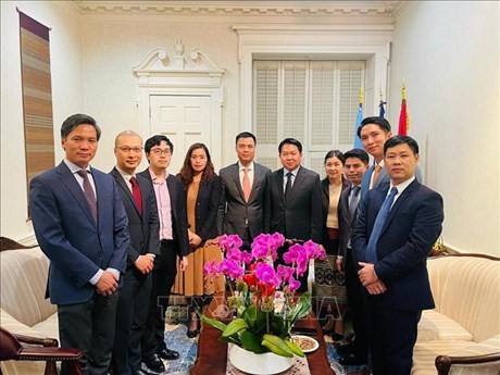 L'ambassadeur Dang Hoang Giang, chef de la Mission permanente du Vietnam auprès de l'ONU (au milieu), félicite son homologue lao à l'occasion du Nouvel An lao. Photo: VNA