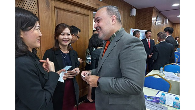 Les entreprises d'IDE échangent les investissements en marge de la conférence. Photo : baodautu.vn 