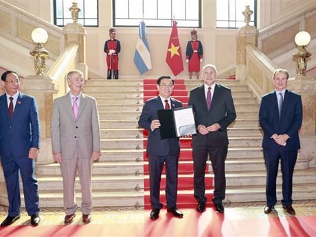 Le Président de l’Assemblée nationale du Vietnam (ANV), Vuong Dinh Huê (au milieu), reçoit le titre d’invité d’honneur décerné par le gouverneur de la province argentine de Santa Fe, Omar Ángel Perotti. Photo : VNA.