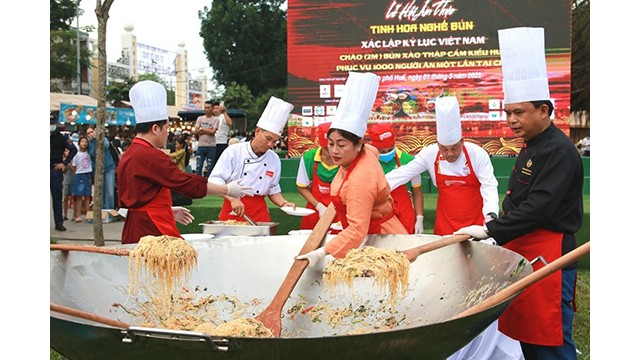 Les cuisiniers ont mis les ingrédients dans une grande casserole de 2m de diamètre pour cuisiner 1 000 plats de vermicelles sautés de style de Huê pour 1 000 personnes. Photo : Journal Thua Thiên Huê.