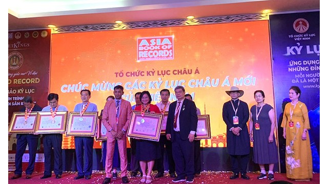 La directrice du Service de la culture, des sports et du tourisme, Huynh Thi Hoài Thu, reçoit le certificat du record d'Asie pour les plats à base de lotus. Photo: dulich.dongthap.gov.vn 