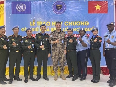 Le Commandant adjoint de la police de la MINUSS, Murat Isik, prend une photo avec les officiers de police vietnamiens et d'autres délégués. Photo : VNA.
