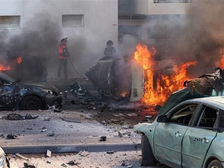 Des gens tentent d'éteindre des incendies de voitures après une attaque à la roquette depuis la bande de Gaza à Ashkelon, en Israël, le 7 octobre 2023. Photo : AFP/VNA