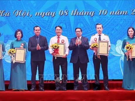 Le Premier ministre Pham Minh Chinh (3e à partir de la droite) avec les auteurs des initiatives exceptionnelles, à Hanoi, le 8 octobre. Photo: VNA