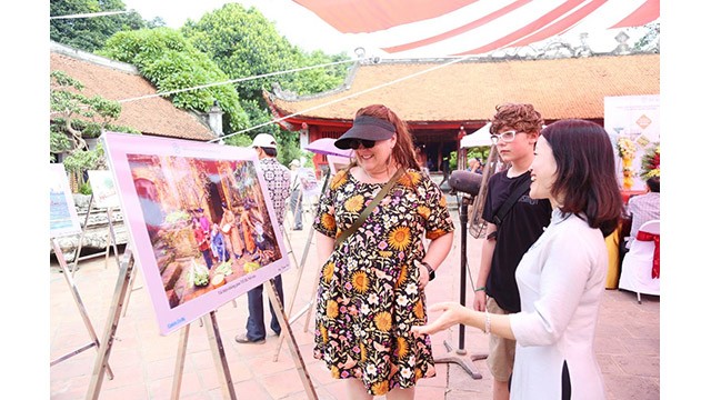 Les touristes visitent l'exposition de photos « Hanoi - 15 ans d'expansion de ses limites administratives » au Temple de la Littérature - Quôc Tu Giam.
