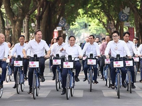 Les Premiers ministres vietnamien et néerlandais font du vélo ensemble dans des rues de Hanoï. Photo : VNA.