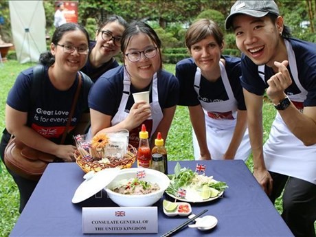 Des membres du consulat britannique apprennent à cuisinier le "phở". Photo : VNA.
