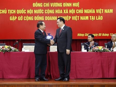 Le Président de l’Assemblée nationale du Vietnam Vuong Dinh Huê (à droite) offre un cadeau au représentant de la communauté des entreprises vietnamiennes au Laos. Photo : VNA.