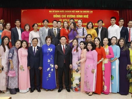 Le Président de l’Assemblée nationale du Vietnam, Vuong Dinh Huê (5e, à partir de la gauche, 1er plan) et les représentants de la communauté vietnamienne au Laos, à Vientiane, le 5 décembre. Photo : VNA.