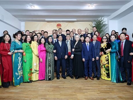 Le Premier ministre Pham Minh Chinh, des membres de la délégation de haut niveau l'accompagnant, des membres du personnel de l'ambassade du Vietnam, et des représentants de la communauté vietnamienne en Roumanie, lors de la rencontre. Photo : VNA.