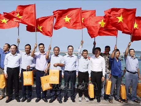 Le Président vietnamien Vo Van Thuong offfre le drapeau national aux pêcheurs du district insulaire de Cô Tô, province de Quang Ninh, au Nord-Est du Vietnam. Photo : VNA.