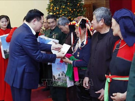 Le Président de l'Assemblée nationale, Vuong Dinh Huê, offre des cadeaux aux personnes bénéficiaires des politiques de l'Etat. Photo : VNA.