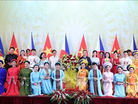 Les Présidents Vo Van Thuong et Ferdinand Marcos Jr. et leurs épouses offrent des fleurs aux artistes présents au banquet organisé le 30 janvier à Hanoi. Photo : VNA.