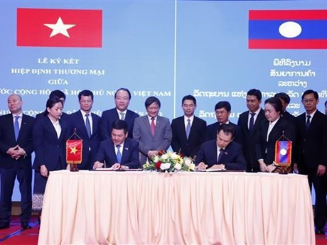  Le ministre de l'Industrie et du Commerce, Nguyen Hong Dien (gauche), et son homologue lao, Malaithong Kommasith, signent un nouvel accord commercial Vietnam-Laos. Photo: VNA