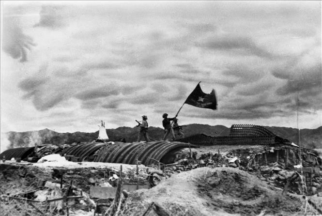 Le drapeau « Déterminé à combattre, déterminé à gagner » de l'Armée vietnamienne flotte au sommet du tunnel de commandement du général français De Castries dans l'après-midi du 7 mai 1954, marquant la victoire complète de la campagne de Dien Bien Phu. Photo d'archives : VNA.