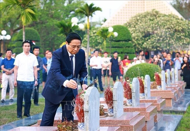 Le Premier ministre Pham Minh Chinh allume de l'encens sur des tombes au Cimetière national des martyrs A1. Photo: VNA