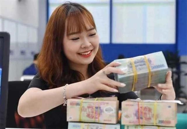 Un caissier de banque compte l’argent dans un bureau de transactions à Hanoï. Photo : cafef.vn