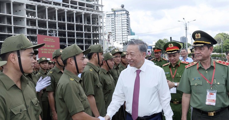 Le Président de la République Tô Lâm serre la main des membres de la force de défense de la sécurité et de l’ordre au niveau local. Photo : VNA.