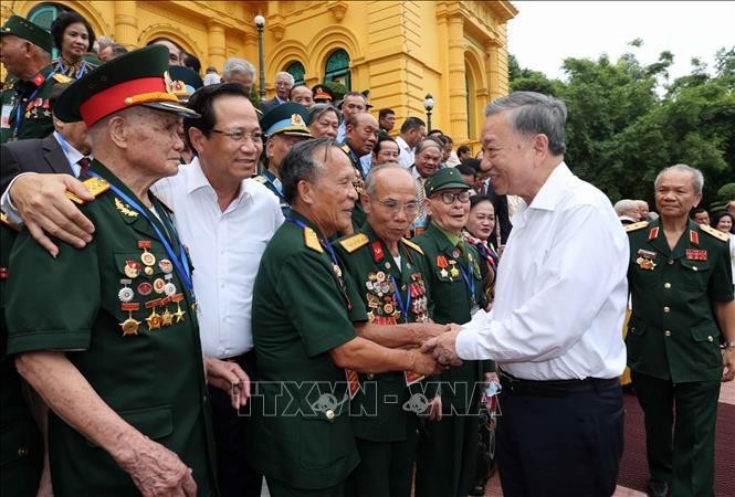 Le Président vietnamien Tô Lâm avec la délégation des personnes ayant rendu des services méritoires à la révolution, à Hanoi, le 22 juillet. Photo : VNA.