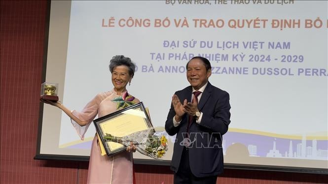 Le ministre vietnamien de la Culture, des Sports et du Tourisme, Nguyen Van Hung, remet la décision de reconduction de Anoa Suzanne Dussol Perran comme ambassadrice du tourisme du Vietnam en France. Photo : VNA.