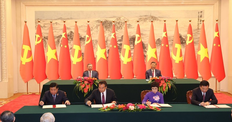 Le secrétaire général et président vietnamien Tô Lâm (à gauche, 2e plan) et son homologue chinois Xi Jinping supervisent la signature de l’Accord de coopération professionnelle entre l’Agence vietnamienne d’information et l’agence de presse Xinhua, à Pékin, le 19 août 2024. Photo : VNA.