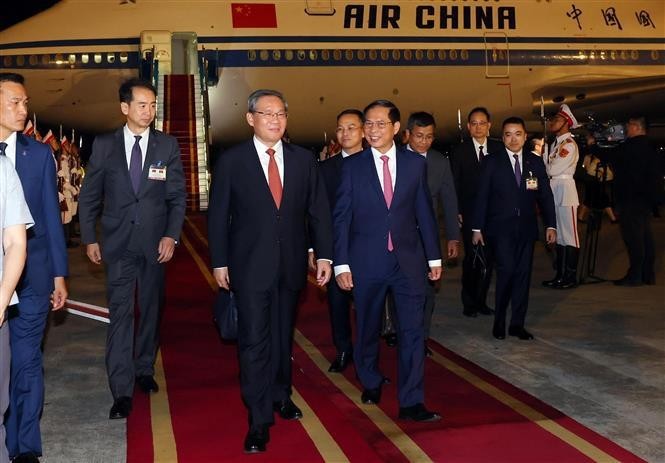 Le Premier ministre chinois Li Qiang (au centre) accueilli à sa descente à l’aéroport international de Nôi Bài, à Hanoi. Photo : VNA.