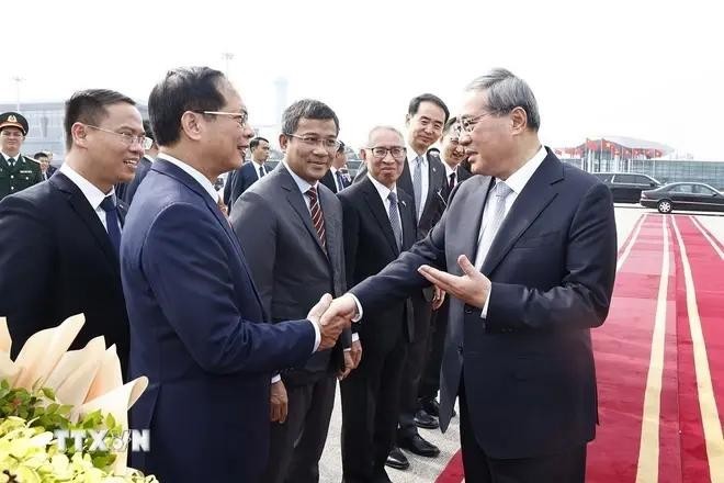 Le vice-Premier ministre et ministre des Affaires étrangères Bui Thanh Son (gauche) a dit au revoir le Premier ministre chinois Li Qiang à l'aéroport international de Noi Bai. Photo : VNA