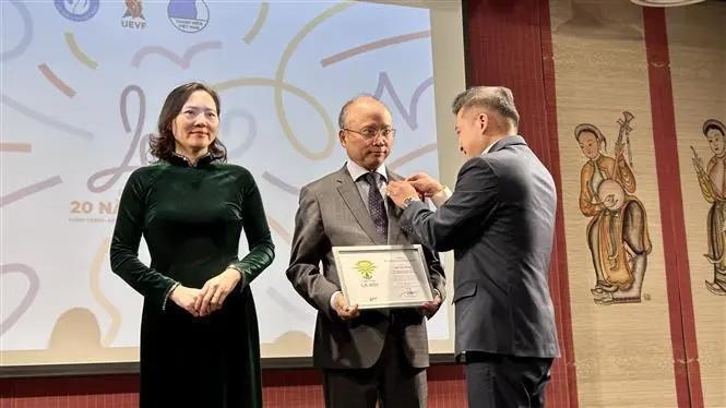 Le président de l'UEVF Nguyen Phan Bao Thuy, remet des insignes à l'ambassadeur du Vietnam en France Dinh Toan Thang et à l'ambassadrice Nguyen Thi Van Anh. Photo : VNA.