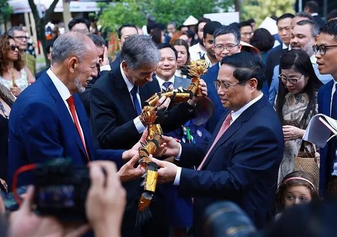 Le Premier ministre Pham Minh Chinh offre des marionnettes sur l'eau à des délégués. Photo : VNA