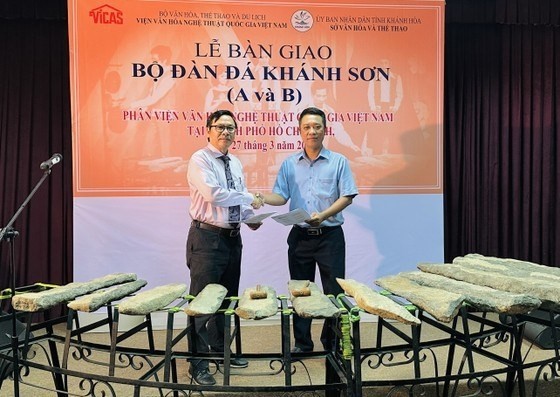 Le chef du sous-Institut national vietnamien des études culturelles et artistiques à Hô Chi Minh-Ville, Dinh Van Hanh (à gauche) remet les lithophones de Khanh Son A et B à un représentant de la province de Khanh Hoa. Photo: SGGP 
