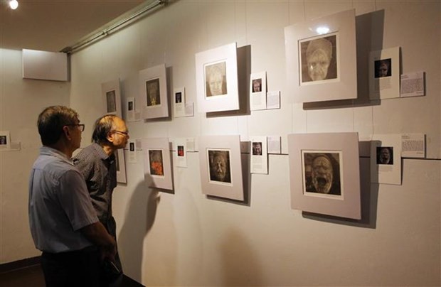 Des visiteurs visitent les peintures de l'espace d'exposition "Finding Parkinsons" de l'artiste David Thomas. Photo : VNA.